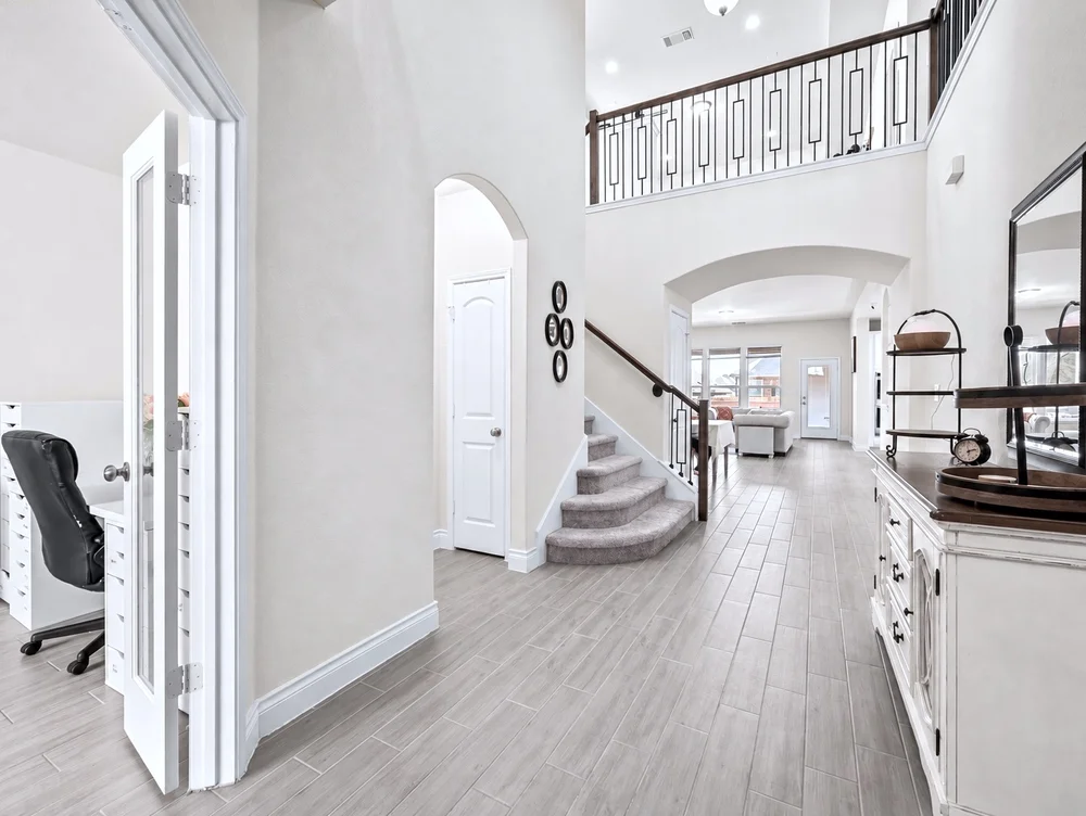 Main-level entry with high ceilings, staircase and views into the living area